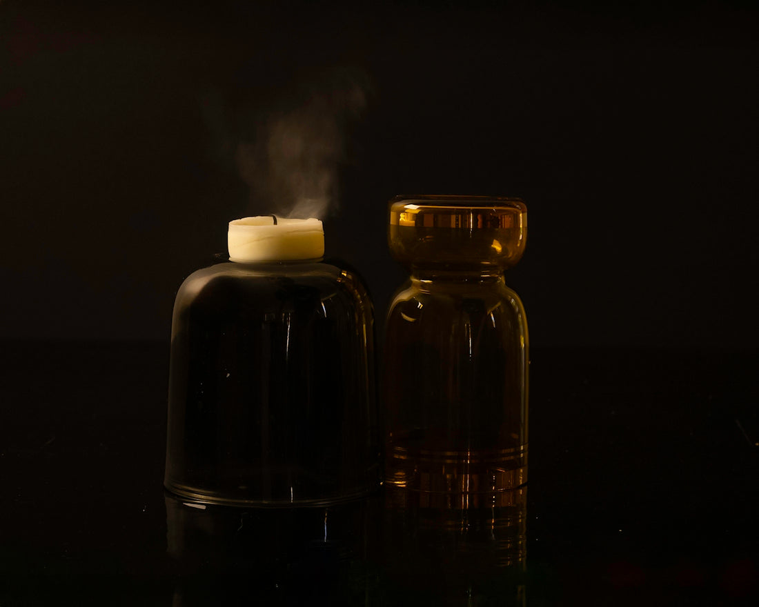 A candle and a bottle on a table
